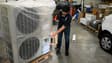 Un ouvrier examine une pompe à chaleur dans son atelier du Val-d'Izé, en Ille-et-Vilaine, le 2 octobre 2023