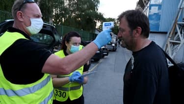 Prise de température d'un journaliste avant un match de football à huis clos à Zagreb, le 7 juin 2020