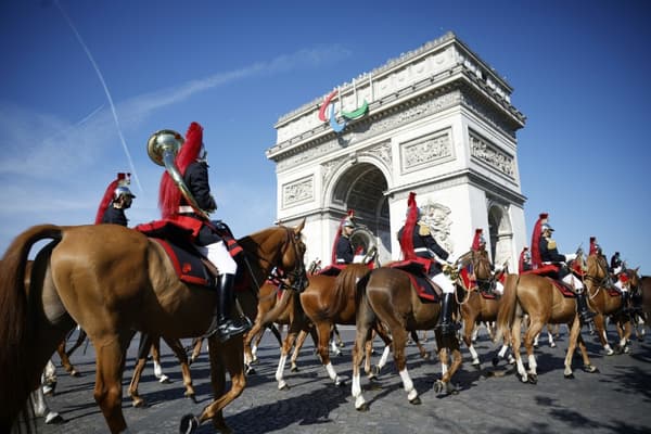Le régiment de cavalerie de la Garde républicaine française arrive pour se préparer au défilé militaire du Jour de la Bastille sur l'avenue Foch, avec l'Arc de Triomphe en arrière-plan, à Paris, le 14 juillet 2024