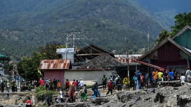 Des habitants marchent le 2 octobre 2018 au milieu des décombres dans le village de Perumnas Balaroa (Indonésie).