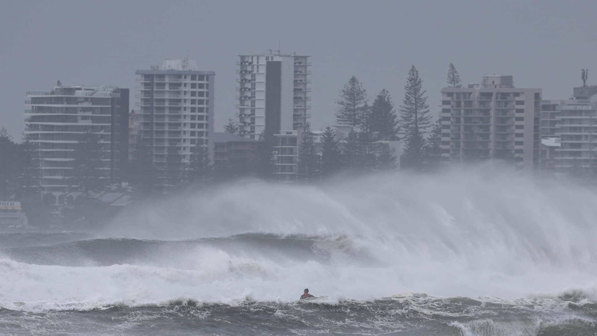 Une personne sur un jet ski tente de remorquer des surfeurs au milieu de vagues record à l'est de l'Australie, à Coolangatta, le 6 mars 2025.