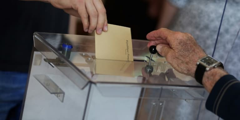Une personne dépose son bulletin de vote dans une urne à Saint-Savin, le 12 juin 2022