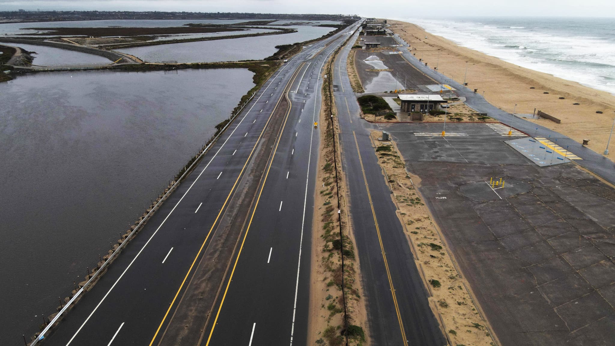 Cette photo aérienne prise le 1er février 2024 montre une section de la Pacific Coastal Highway fermée en raison d'une inondation lors d'une tempête de pluie à Bolsa Chicaen Californie.