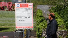 Un homme en train de contempler le faux permis de démolir déployé par le collectif d'artistes "Le Bruit qui court" à Grenoble.