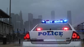 Une voiture de police au pied du pont de Brooklyn, à New York, à l'approche de l'ouragan Sandy, lundi en début de soirée.