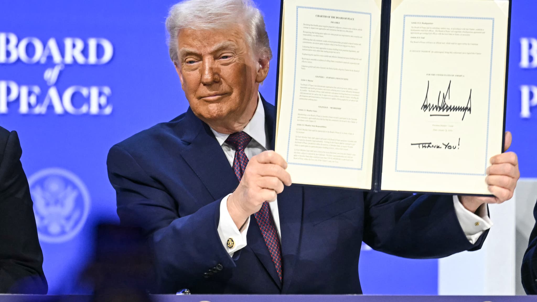 Le président américain Donald Trump tient la charte fondatrice signée lors de la réunion du "Conseil de la paix" au Forum économique mondial (WEF) à Davos, le 22 janvier 2026.