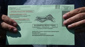 Une électrice tient une enveloppe renfermant son bulletin de vote pour la présidentielle américaine, le 16 octobre 2020 à Phoenix, en Arizona
