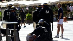 Des policiers viennent en aide à un supporter britannique agressé par des hooligans russes lors de l'Euro de football le 11 juin 2016 à Marseille.
