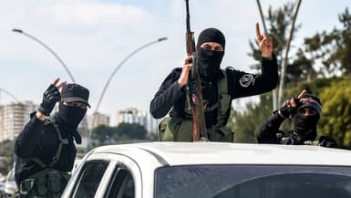Les forces de sécurité fidèles au gouvernement syrien intérimaire font un geste à l'arrière d'un véhicule circulant sur une route de la ville de Lattaquié, dans l'ouest de la Syrie, le 9 mars 2025.