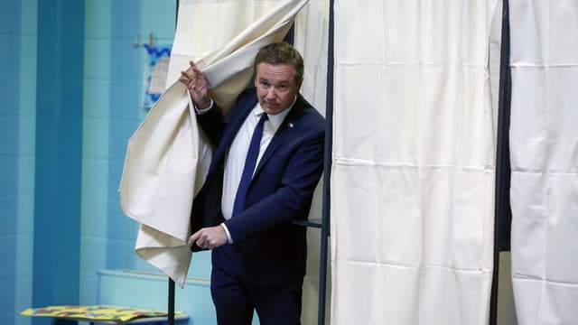 Nicolas Dupont-Aignan (Debout la France) sort de l'isoloir, le 23 avril 2017 à Yerres, lors du 1er tour de l'élection présidentielle.