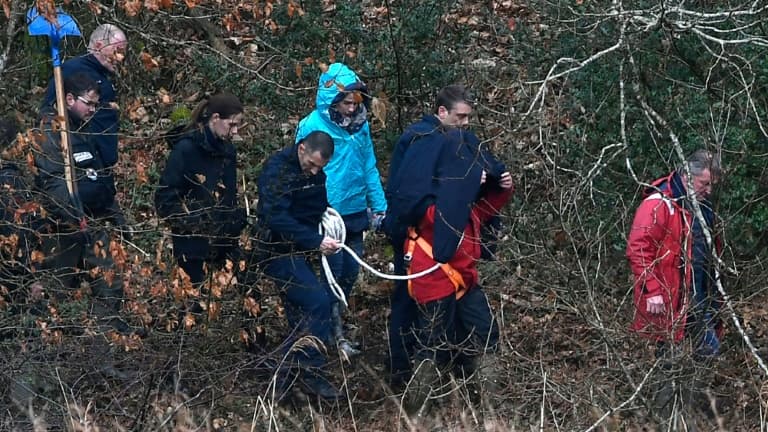 Hubert Caouissin (caché) et son avocat sont accompagnés par la police lors d'une reconstitution près de la rivière Aulne à Pont-de-Buis le 12 mars 2019 Hubert Caouissin (caché) et son avocat sont accompagnés par la police lors d'une reconstitution près de la rivière Aulne à Pont-de-Buis le 12 mars 2019