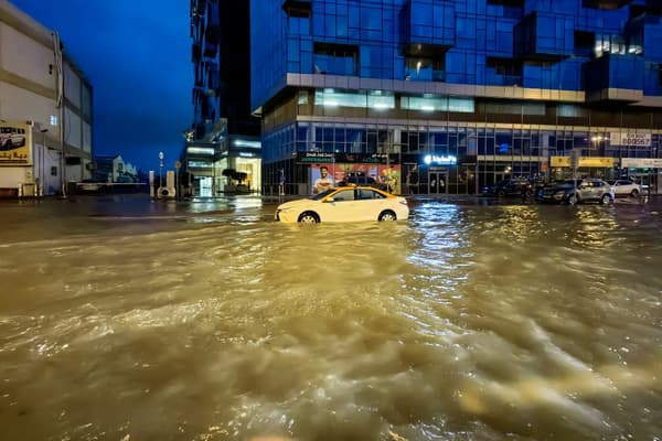 Un taxi traverse une rue inondée suite à de fortes pluies à Dubaï, le 17 avril 2024