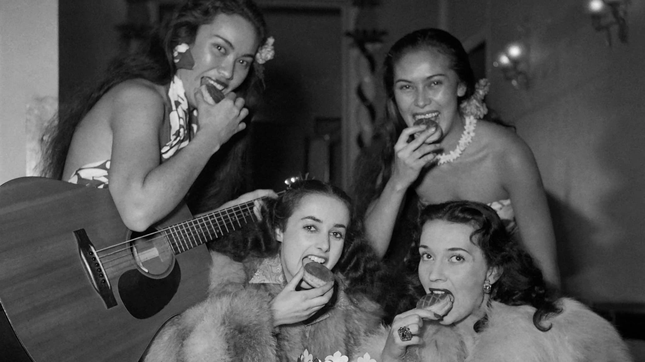 La danseuse française Liane Daydé (2e à gauche) mange un morceau de galette des rois avec d'autres invités pour célébrer l'Épiphanie. Paris, janvier 1951.