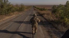 Un soldat ukrainien de la 65e brigade mécanisée marche sur une route près du village de Robotyne, dans la région de Zaporizhzhia, le 1er octobre 2023, alors que la Russie envahit l'Ukraine. Lorsque l'Ukraine a annoncé la libération du village de Robotyne le 28 août 2023, le message envoyé au monde était qu'une percée du front russe était enfin possible sur la ligne de front méridionale. Six semaines plus tard, les soldats ukrainiens de la 65e brigade, les premiers à être entrés dans le village, admettent que leur contrôle reste partiel, s'adressant aux journalistes de l'AFP dans une zone habituellement fermée aux médias.