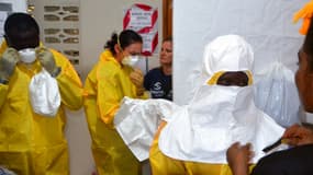 Du personnel soignant en train de revêtir le matériel de protection contre le virus Ebola au Liberia