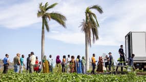 Des personnes font la queue lors d'une distribution d'eau dans la ville de Mamoudzou, à Mayotte, après le passage du cyclone Chido sur l'archipel, le 23 décembre 2024.
