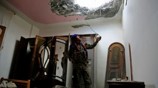 Un combattant des Forces démocratiques syriennes (FDS), regarde les dégâts dans le toit d'une maison, dans un quartier de l'Est de Raqa, lors d'une offensive contre l'EI, le 14 juin 2017 Un combattant des Forces démocratiques syriennes (FDS), regarde les dégâts dans le toit d'une maison, dans un quartier de l'Est de Raqa, lors d'une offensive contre l'EI, le 14 juin 2017
