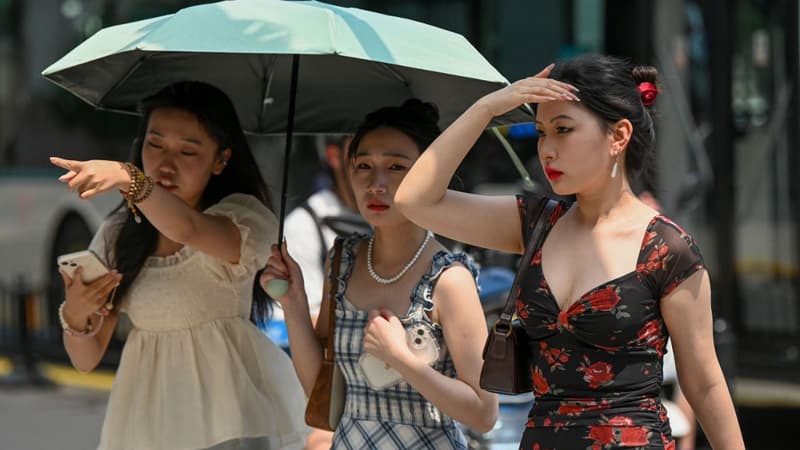 Trois femmes qui s'abritent sous un parapluie alors que Shanghai enregistre la journée de mai la plus chaude depuis 100 ans le 29 mai 2023