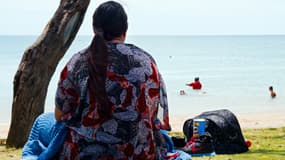 Une femme assise le long de la plage face à la mer à Nouméa, en Nouvelle-Calédonie, le 1er décembre 2014 (photo d'illustration)