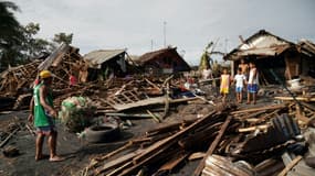 Des habitants fouillent les débris de leurs maisons détruites par le typhon Rai en quête d'objets personnels, à Dulaq aux Philippines le 17 décembre 2021