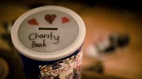 Une photographie de boite à sous avec une inscription "banque de la charité" sur le couvercle