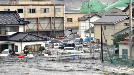 Rues inondées à Kenennuma, dans la préfecture de Miyagi. Le bilan du séisme survenu vendredi au japon et du tsunami qui a suivi devrait dépasser le millier de morts, selon l'agence de presse Kyodo. /Photo prise le 11 mars 2011/REUTERS/YOMIURI