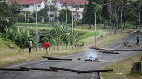 Des habitants marchent le long d'une rue bloquée dans le quartier des Jacarandas à Dumbéa, en Nouvelle-Calédonie, territoire français du Pacifique, le 2 juin 2024. 