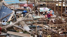 Des personnes cherchent des affaires et tentent de reconstruire au milieu des dégâts de l'habitat précaire du bidonville de l'agglomération kaweni de Mamoudzou.