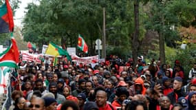 Des milliers de personnes issues de la diaspora ultramarine, vêtues de rouge, manifestent le 3 novembre 2024 à Paris contre la vie chère en Outre-mer.