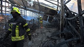 Des pompiers ukrainiens dans un hypermarché de bricolage à Kharkiv touché par une frappe russe le 25 mai 2024