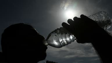 Une personne boit de l'eau dans une bouteille en plastique à Mulhouse, dans l'est de la France, le 25 juin 2019.