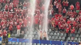 Deux supporters du Danemark dansent sous des trombes d'eau lors du match face à l'Allemagne