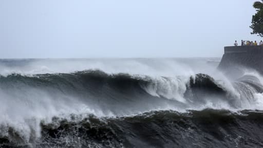 Des curieux viennent admirer le spectacle formé par la mer agitée, à Saint-Denis-de-la-Réunion. Des vagues de 10 mètres de hauteur sont attendues sur les côtes de l'île.
