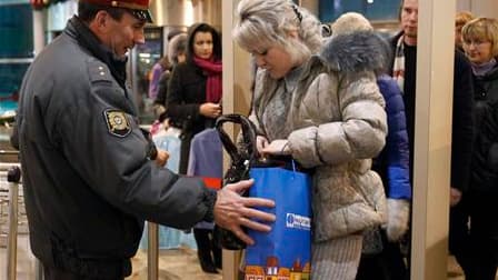 Un policier vérifie les effets personnels d'une passagère à l'aéroport Domodedovo de Moscou. Le président russe Dmitri Medvedev a dénoncé les failles dans la sécurité du premier aéroport de Russie, où un attentat suicide a fait au moins 35 morts et plus d