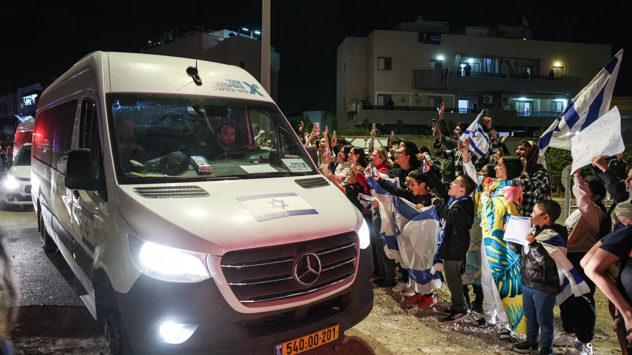 Des personnes acclament un véhicule transportant des otages libérés par le Hamas, dans le sud d'Israël, le 26 novembre 2023. Des personnes acclament un véhicule transportant des otages libérés par le Hamas, dans le sud d'Israël, le 26 novembre 2023.