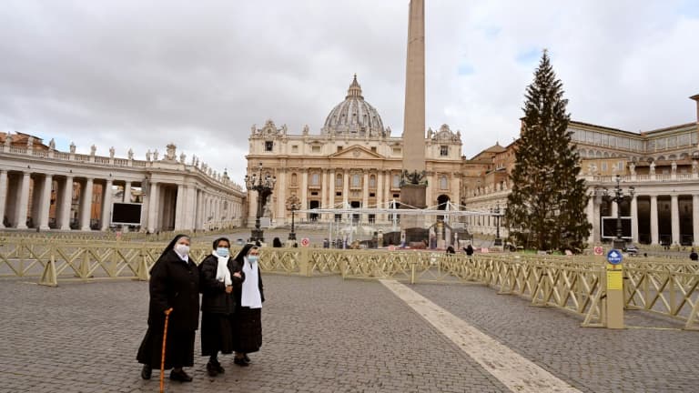 Des religieuses marchent sur la place Saint-Pierre déserte à cause du confinement lié à la pandémie de coronavirus, à Rome le 25 décembre 2020