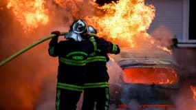 Les pompiers interviennent sur une voiture incendiée pendant des violences à Lille, le 29 juin 2023