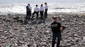 Des inspecteurs de police examinent des débris sur la plage de Saint-Denis, à la Réunion