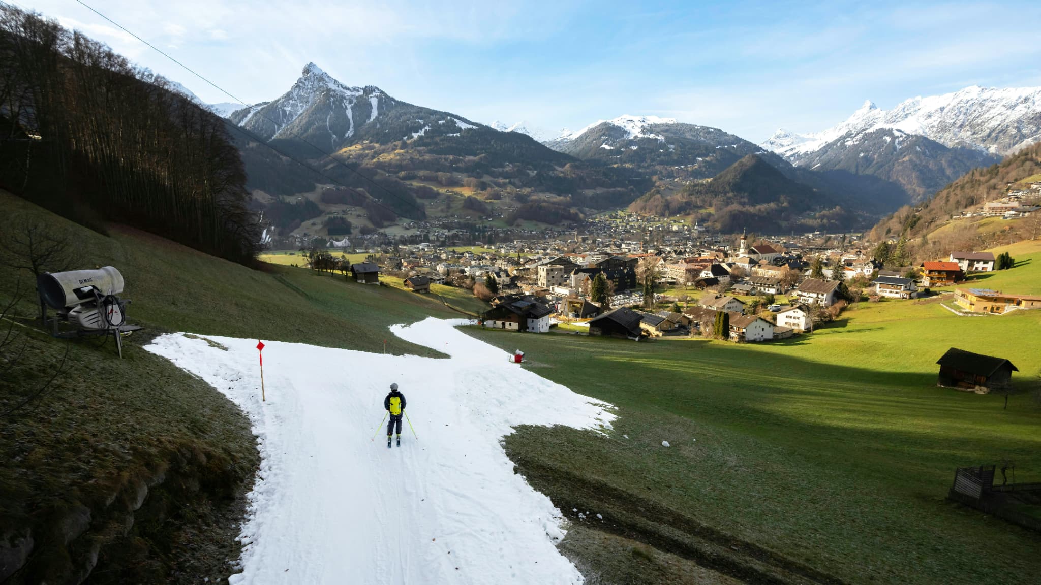 Un skieur confronté au manque d'enneigement sur une piste à Schruns, en Autriche, le 28 décembre 2023 Un skieur confronté au manque d'enneigement sur une piste à Schruns, en Autriche, le 28 décembre 2023