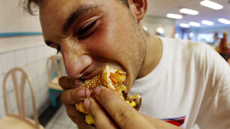 Un homme mangeant un hamburger dans un McDonalds de Miami, en 2002.