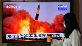 Une femme passe devant un écran de télévision diffusant des images d'un tir de missile nord-coréen, le 29 mars 2020 dans une gare de Séoul, en Corée du Sud