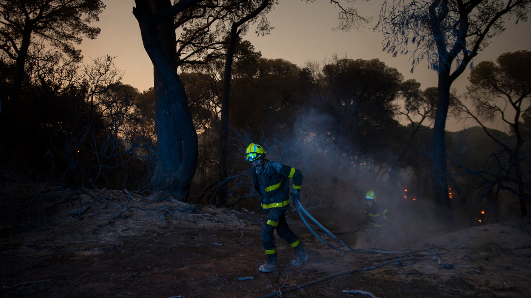 Des pompiers tentent d'éteindre un feu de forêt à Puerto Real, près de Cadix en Espagne, le 6 août 2023. Des pompiers tentent d'éteindre un feu de forêt à Puerto Real, près de Cadix en Espagne, le 6 août 2023.