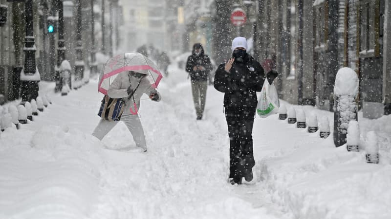 Les gens marchent à Madrid au milieu d'une forte chute de neige le 9 janvier 2021.