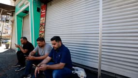 DeS Palestiniens en grève devant leur magasin, Ramallah, le 31 juillet 2024