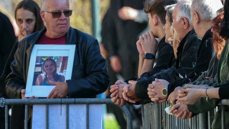 Un homme tient un portrait de Lina devant l'église Saint-Arnould lors des funérailles de l'adolescente, le 25 octobre 2024 au village de Plaine, dans le Bas-Rhin