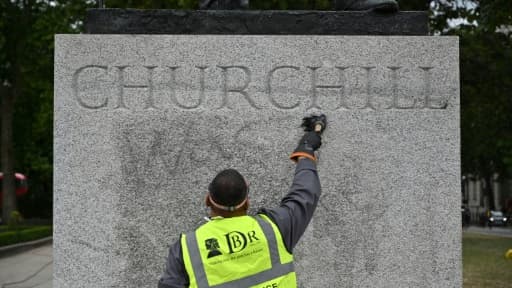 Nettoyage de la statue de l'ancien Premier ministre britannique Winston Churchill pour ôter un graffiti affirmant qu'il "était un raciste", à Londres le 8 juin 2020