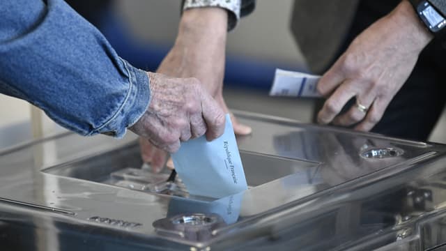 Une personne glisse un bulletin de vote dans l'urne pour le premier tour de l'élection présidentielle à Paris, le 10 avril 2022.