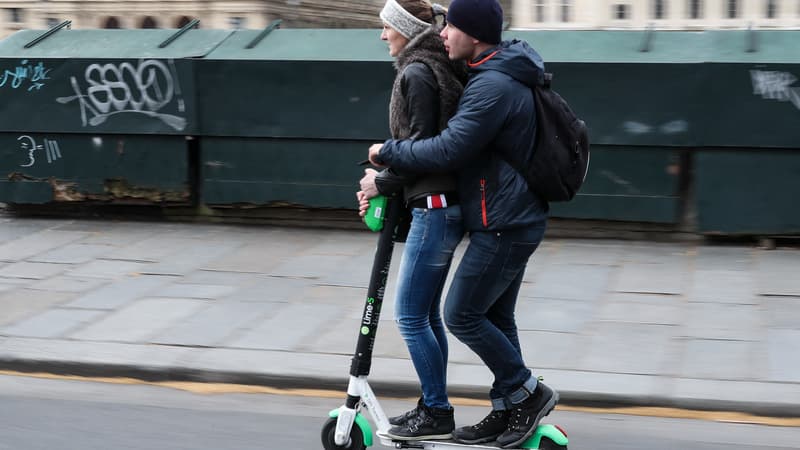 Deux usagers sur une trottinette Lime dans les rues de Paris en mars 2019