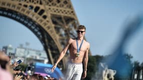 Le Français Léon Marchand célébrant ses médailles devant la tour Eiffel