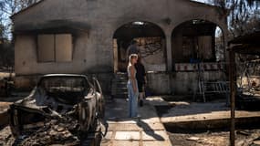 Des propriétaires regardent les dégâts de leur maison brûlée suite à un incendie de forêt qui a touché la banlieue nord-est d'Athènes, à Chalandri, banlieue d'Athènes, le 13 août 2024.